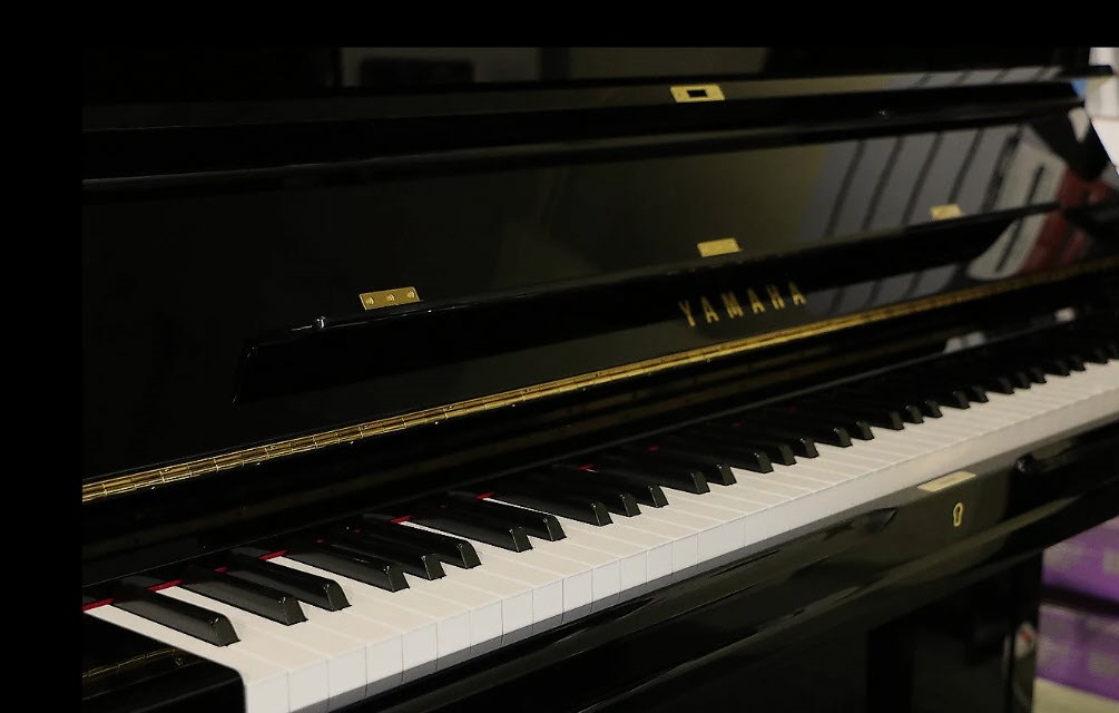 Black Yamaha U3 upright piano with white keys